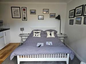 a bedroom with a bed with a purple comforter at Modern immaculate studio with AC & parking, outside the CAZ in Bristol
