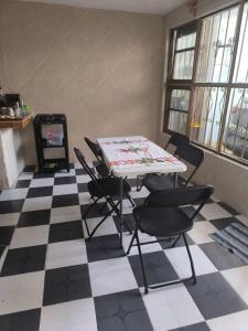 Habitación con mesa y sillas en un suelo a cuadros en Adelita, en Atlixco