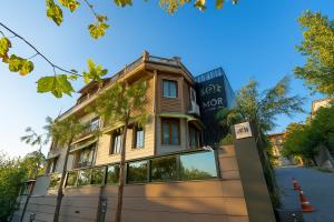 a building with palm trees in front of it at Magia Hotel - Spa & Wellness in Avcılar