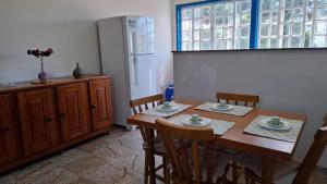 a kitchen with a table and chairs and a refrigerator at SUÍTE Solar do Carmo in Mariana