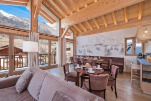 un soggiorno con un divano, un tavolo e delle sedie di Chalet Stella Montis - Luxe et Proximité des Pistes a Praranger Altre 13 foto
