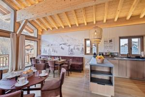 una sala da pranzo e una cucina con tavoli e sedie di Chalet Stella Montis - Luxe et Proximité des Pistes a Praranger