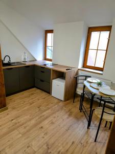 a kitchen with a table and chairs in a room at Apartmány Ždiar in Ždiar +14 photos