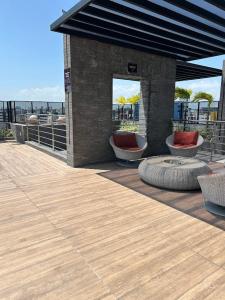 patio z 2 krzesłami oraz budynek z widokiem na ocean w obiekcie Std Time Maceió w mieście Maceió