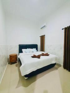 a bedroom with a large bed with white sheets and brown blankets at Cliff House Bali With Private Pool in Sukasada +26 photos