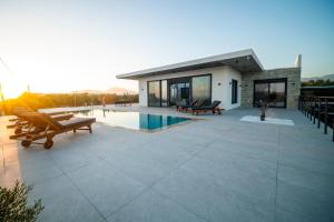 a large patio with benches and a house at Antiope Retreat in Pitsidia