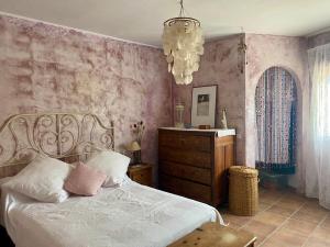 a bedroom with a bed and a dresser and a chandelier at La Casita Azul in Santa Fe de los Boliches