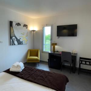 a bedroom with a bed and a desk and a television at Patio De Violette in Uzès +59 photos