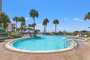 a swimming pool at a resort with palm trees at Grand Panama by Panhandle Getaways in Panama City Beach