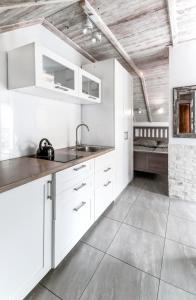 a kitchen with white cabinets and a sink at Apartament z tarasem in Stegna