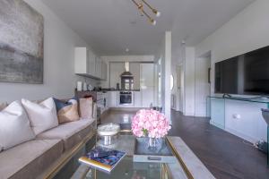 a living room with a couch and a table with flowers at Modern 2BR Flat with 3 Beds Urban Getaway - Cherry in London