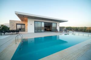 a swimming pool in front of a house at Antiope Retreat in Pitsidia