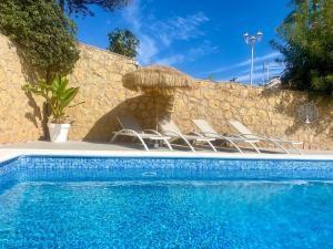 a pool with chairs and umbrellas next to a wall at Casa Montebello in Cautivador +23 photos