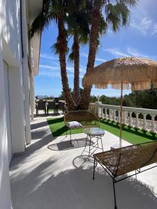 a patio with two chairs and a table and an umbrella at Casa Montebello in Cautivador