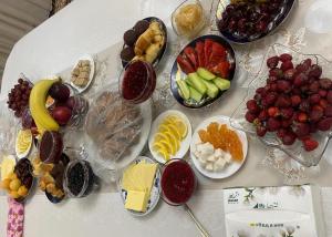 a table topped with different types of fruits and desserts at Talas guest house in Talas