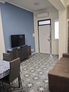 a room with a television and a door with a table and chair at La DIMORA del BORGO Apartment in Casalbuono