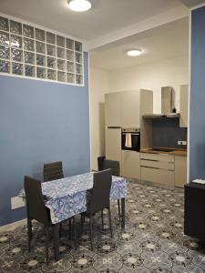 a dining room with a table and chairs and a kitchen at La DIMORA del BORGO Apartment in Casalbuono