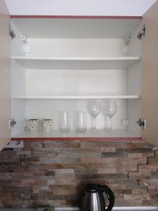 una mensola con tre bicchieri di vino sopra di Guest House Plovdiv a Plovdiv Altre 14 foto