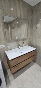une salle de bain avec un lavabo et un miroir dans l'établissement SeaLuxe Residence, à Saranda 31 autres photos