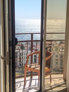 New apartments in Arcadia sea view في أوديسا: كرسي على شرفة مطلة على المحيط