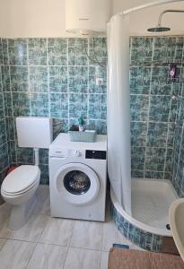 a bathroom with a toilet and a washing machine at Apartment Viniška in Vinišće +43 photos