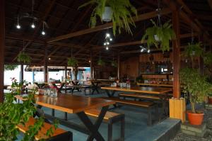a restaurant with wooden tables and potted plants at Kasamba Resort in Dondo