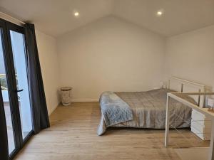 een slaapkamer met een bed en een groot raam bij Villa Júlia, Mountain retreat in Santa Cruz