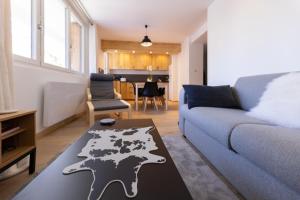 ein Wohnzimmer mit einem blauen Sofa und einem Tisch in der Unterkunft T3 entièrement rénové, à 3 minutes des pistes in La Salle Les Alpes + 2 Fotos