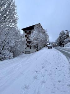 eine schneebedeckte Straße mit einem Gebäude und einem Auto darauf in der Unterkunft T3 entièrement rénové, à 3 minutes des pistes in La Salle Les Alpes