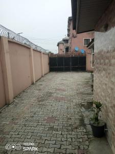 an empty courtyard with a fence and a brick sidewalk at Ogoni Kitchen Hotel in Port Harcourt