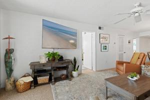 a living room with a couch and a tv on the wall at 512 - Oceanfront top floor corner 2 bedroom in New Smyrna Beach