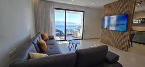 un salon avec un canapé bleu et une télévision dans l'établissement SeaLuxe Residence, à Saranda
