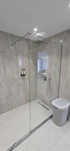 une douche avec une porte vitrée dans une salle de bain dans l'établissement SeaLuxe Residence, à Saranda