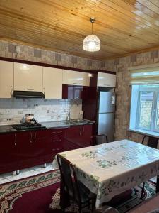 een keuken met een tafel, een fornuis en een koelkast bij Villa Vip in Gabala
