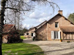 an old brick house with a driveway in front of it at La Petite Sologne in Chaumont-sur-Tharonne