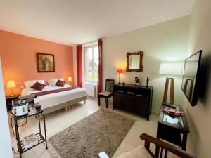 a bedroom with a bed and a desk with a mirror at La Petite Sologne in Chaumont-sur-Tharonne