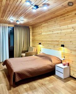 a bedroom with a bed and a chair in it at Joy WoodRest in Voropayev
