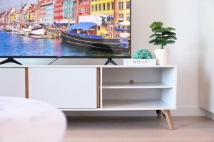 a tv on a dresser in a living room at 14D Abnb-Style Elegant CBD Sanctuary with Balcony, Pool and Skyline Views in Melbourne +51 photos
