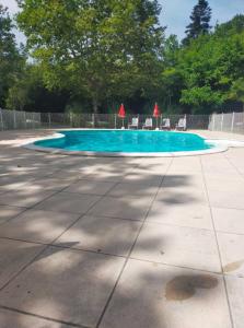- une piscine avec des chaises et de l'eau bleue dans l'établissement Chalet cozy dans Village au cœur des pins, parking gratuit, à Onesse-et-Laharie