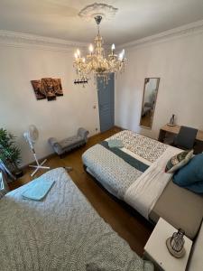 a bedroom with two beds and a chandelier at B1 Appart 2022 - 10min PARIS/EXPO - 5 rooms/6 beds in Bagneux