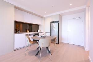 a kitchen with a table and chairs in a room at 14D Abnb-Style Elegant CBD Sanctuary with Balcony, Pool and Skyline Views in Melbourne