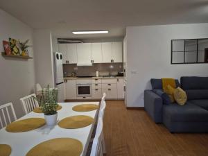 a living room with a table and a blue couch at Apartamento la Última Orilla - Mar y Garaje in Malpica
