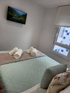 a bedroom with a bed with two pillows and a window at Summer Malpica - calma junto al mar in Malpica
