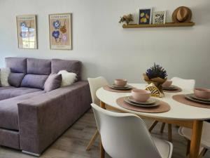 a living room with a couch and a table with chairs at Summer Malpica - calma junto al mar in Malpica