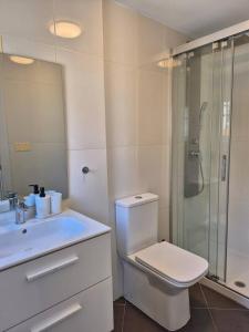 a white bathroom with a toilet and a shower at Summer Malpica - calma junto al mar in Malpica +29 photos