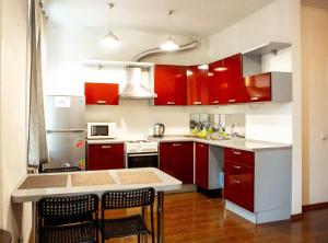 a kitchen with red cabinets and a kitchen island at Doba In Ua Centre Apartments in Dnipro