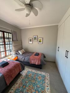 比勒陀利亚Around the corner的一间带两张床和吊扇的卧室