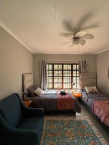 比勒陀利亚Around the corner的一间带两张床和吊扇的卧室