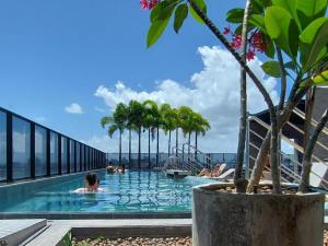 a pool on the roof of a building with people in it at TIME Ponta Verde in Maceió