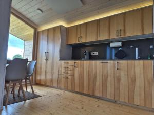 a kitchen with wooden cabinets and a table and chairs at 403 Cozy Tiny House an der Elbe in Bleckede